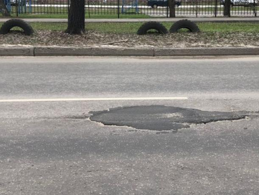 Прожорливую дорожную яму в Воронеже «накормили» асфальтом